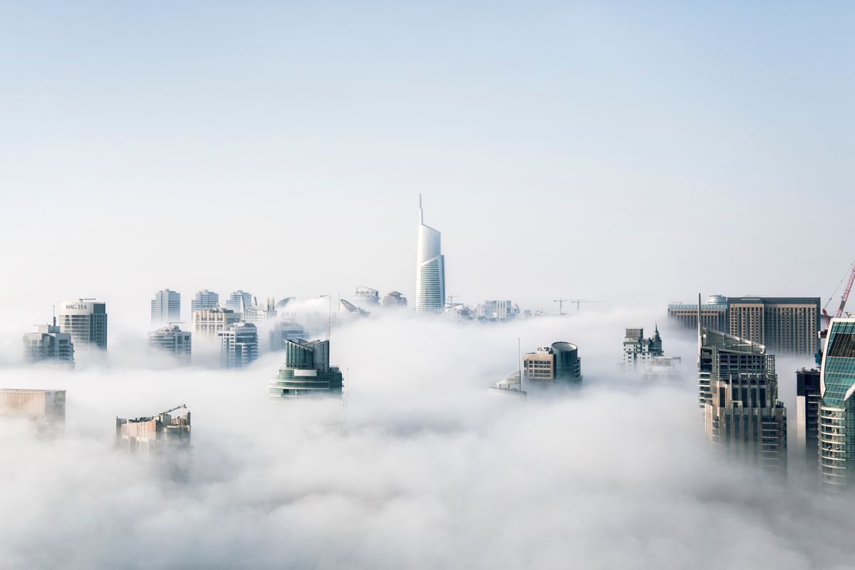 Real city skyline above clouds